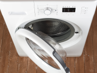 A white ventless dryer sits on a brown floor with its door open