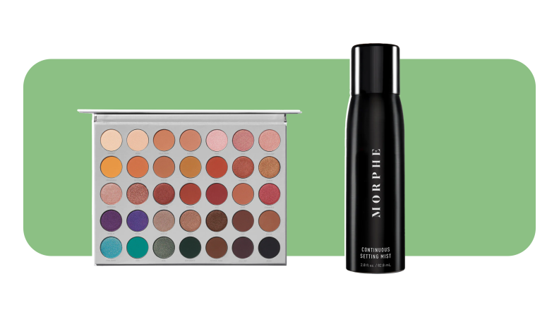 A large, colorful eyeshadow palette sits next to a black bottle of makeup setting spray.