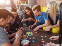 Adults sitting around table playing board game
