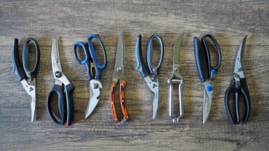 Eight sets of poultry shears on wooden surface