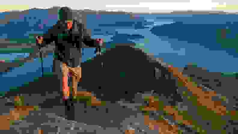 Man hiking on top of mountain wearing Darn Tough Vermont socks.