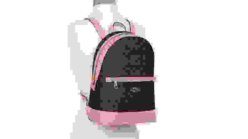 A brown and pink Coach backpack on a mannequin.