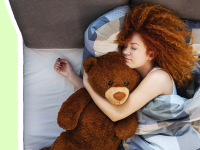Woman sleeping in bed with brown teddy bear