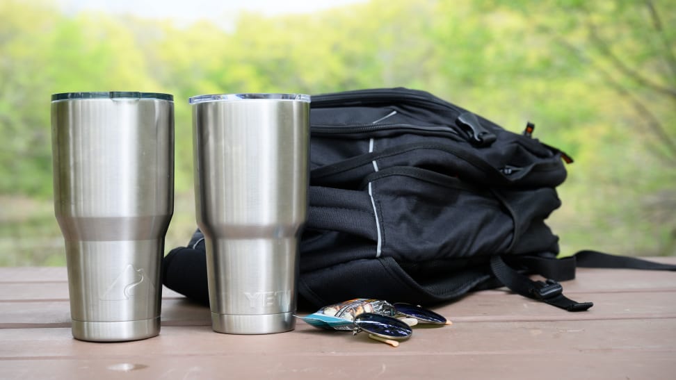 An Ozark Trail tumbler and a Yeti rambler sitting on a table.