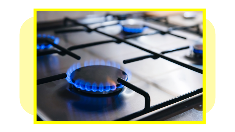 Gas kitchen stove with blue flames burning.