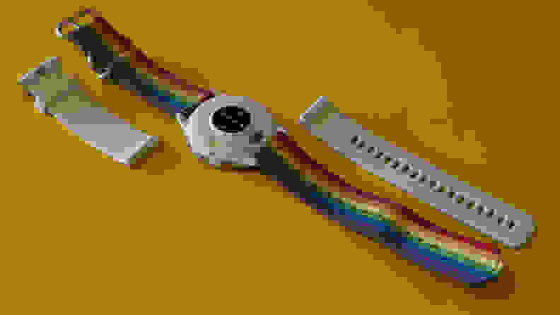 Garmin Venu 3 smartwatch with rainbow woven band next to detached white silicone band.