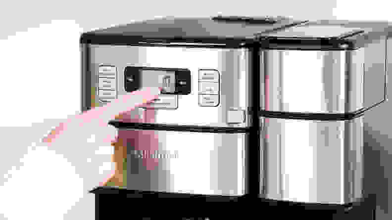 A person pressing buttons on the Cuisinart Grind and Brew Plus control panel.