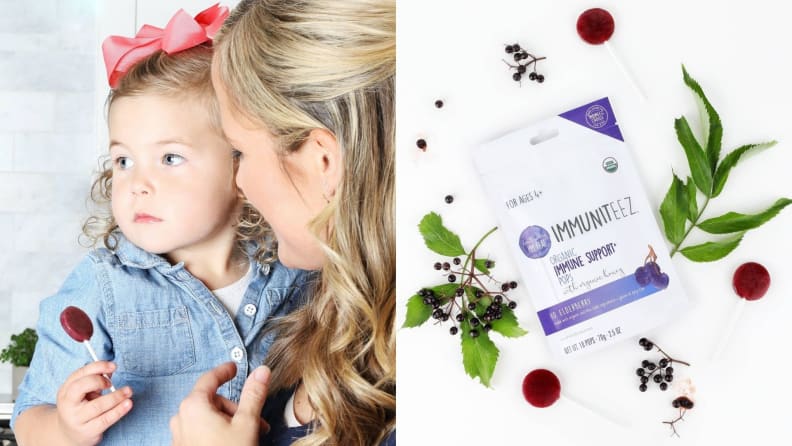 Left: A mother holds a young girl dressed in a blue shirt, holding an elderberry lollipop and looking off into the distance. Right: A top-down photo of a white bag of organic elderberry lollipops with elderberries and leaves surrounding it.