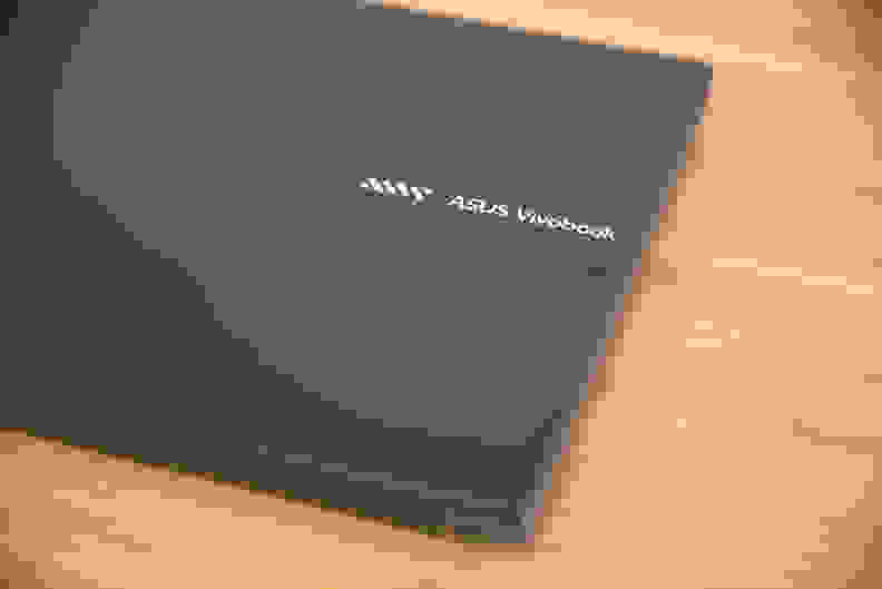 A close-up of a logo on top of a closed laptop