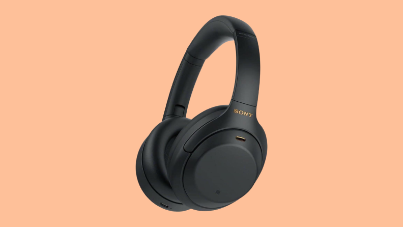 Black Sony headphone on an orange background.