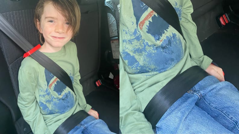 A boy sitting in a car wearing the mifold booster. The lap belt is low on his hips.