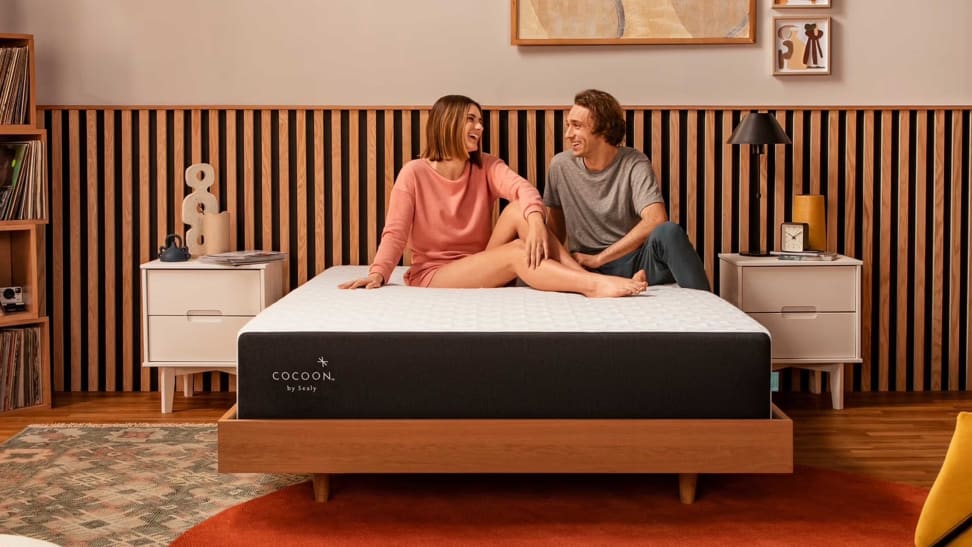 A couple on top of a Cocoon by Sealy Chill mattress in a bedroom setup.
