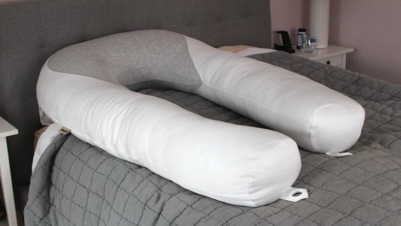 The Hugl Body pillow with a white cover, resting on top of a bed.