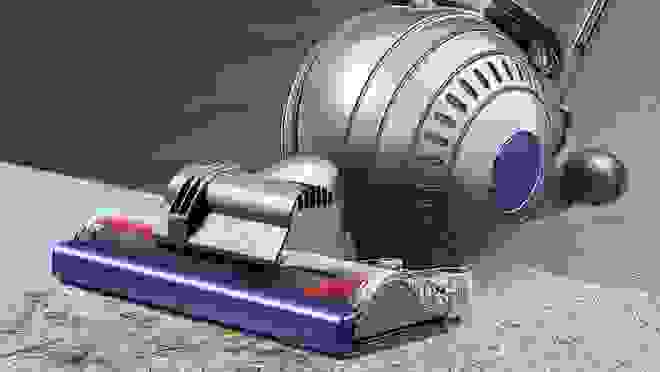 Purple and silver Dyson vacuum on gray carpet