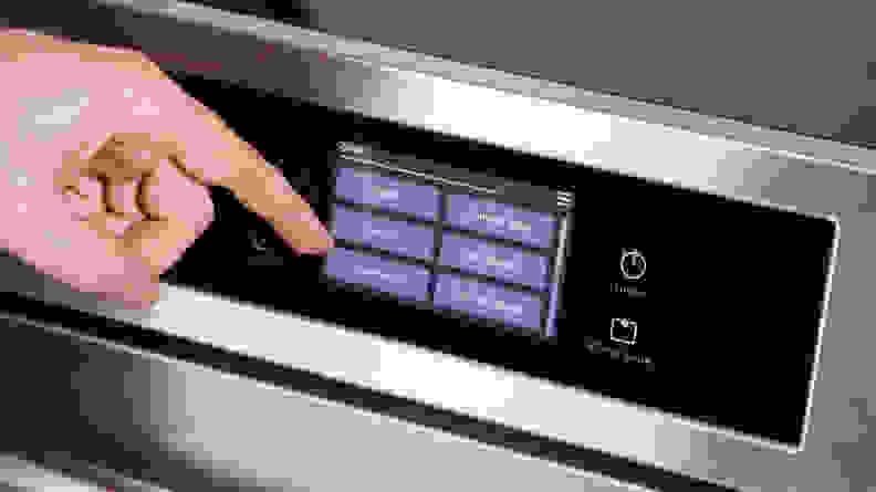A person tapping the touch screen menu on the Frigidaire Gallery stove.
