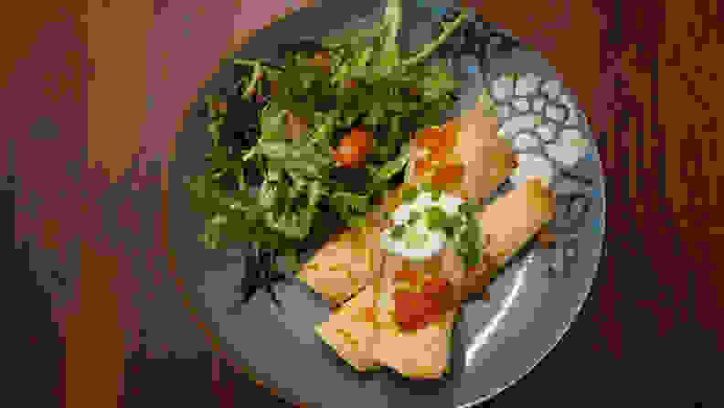 Beef and Corn Taquitos with Chopped Salad on a grey plate viewed from above.