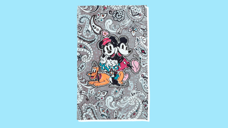 A grey blanket with a paisley pattern and Mickey, Minnie, Goofy and Pete the cat.