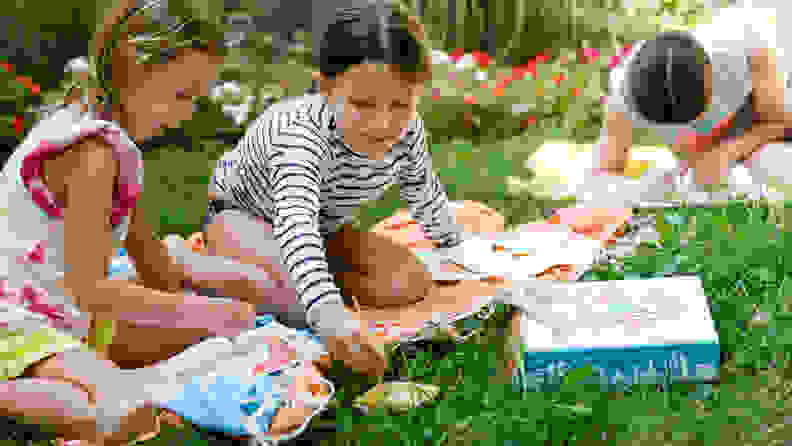 Two girls painting in the backyard