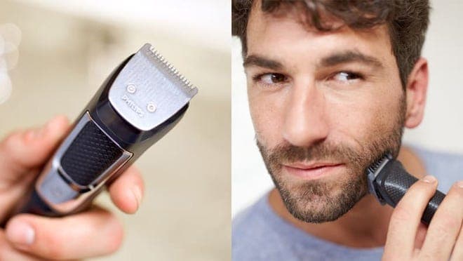 A person uses a beard trimmer