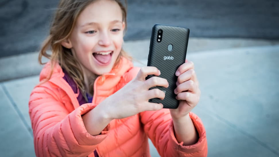 A young girl takes a selfie with a Gabb phone