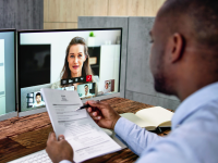 Man holding his resume doing a virtual job interview