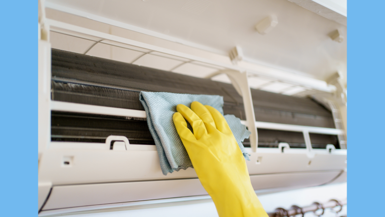 Person cleaning a dirty and dusty air conditioning filter in their house.