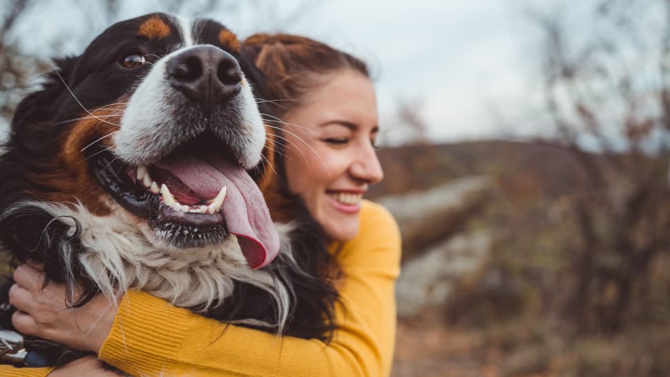 A photo of a woman hugging a dog.