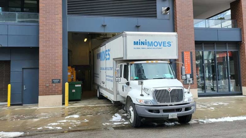 Half of the body of a moving truck parked inside a building garage