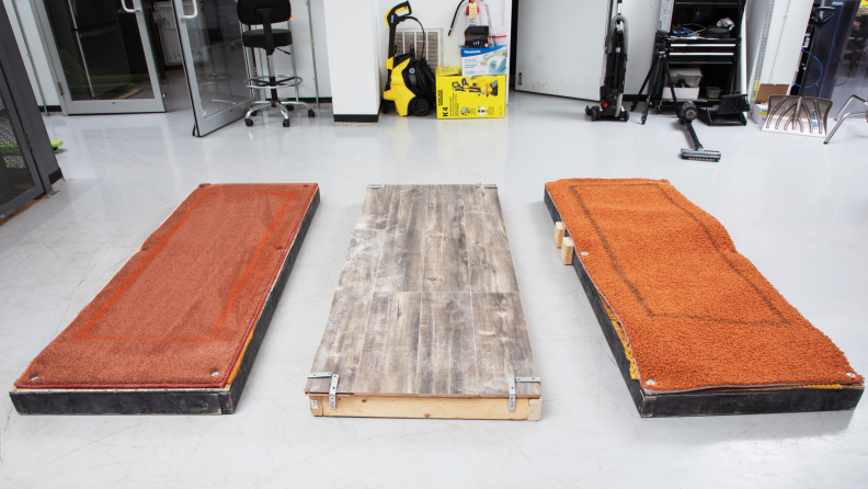 A photo of three different flooring types: medium pile carpet, high pile carpet and hardwood used for vacuum testing