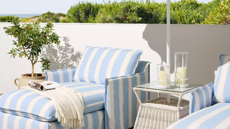 blue and white striped outdoor chaise lounge chairs next to patio table