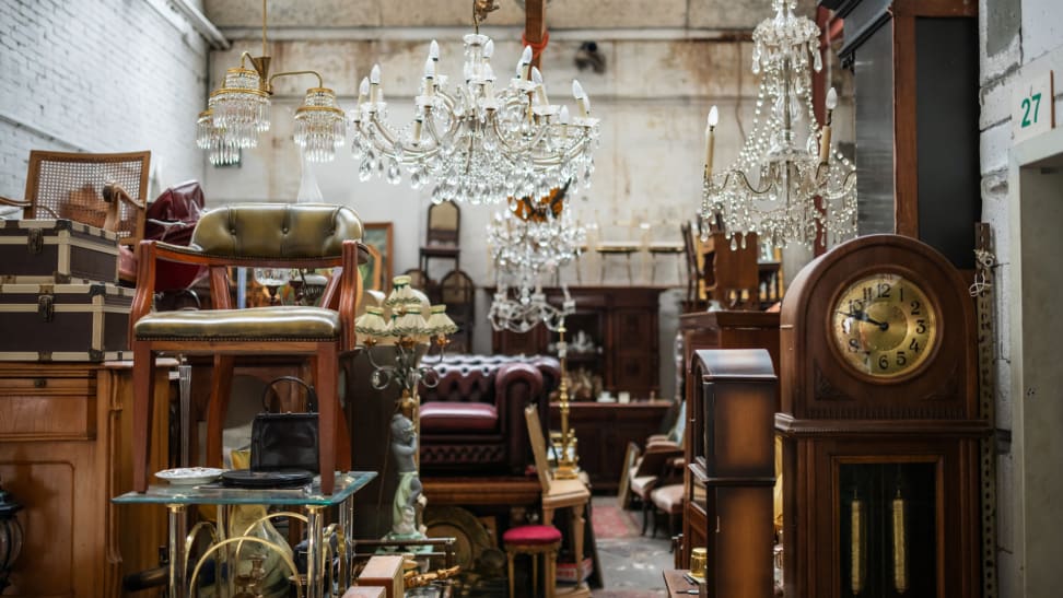 Many pieces of secondhand vintage furniture in a store, including wooden dressers and clocks
