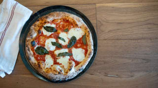 Here's a classic margherita pizza next to a dish towel.