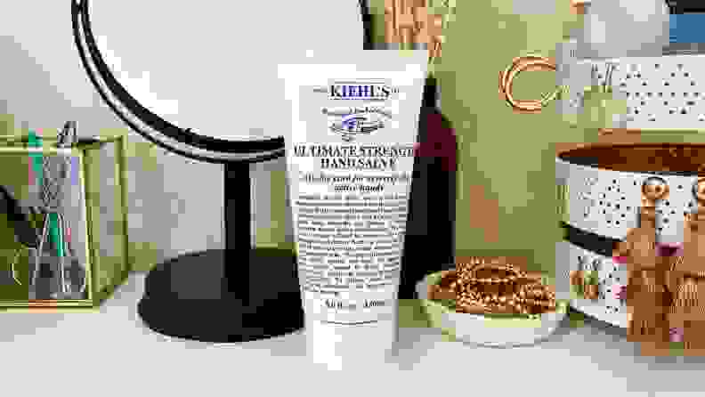 Kiehl's hand cream sitting on table next to mirror and jewelry