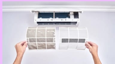 A person holding up two air conditioner filters. The left filter is dirty and the right is clean.
