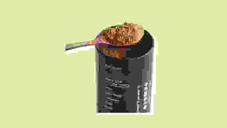 A container of Mud Wtr with a spoon of powder.