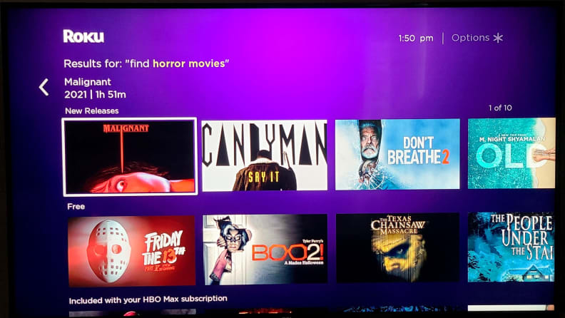 The Roku menu is shown on TV screen, with multiple streaming app squares against a purple background, with horror movies called up via voice search.