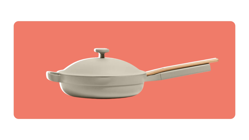 A side view of the Our Place Always Pan in Steam color with wooden spoon resting on handle.