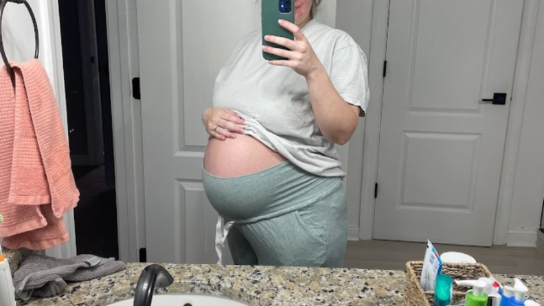 Pregnant person taking a mirror photo while wearing Seraphine's maternity lounge pants.