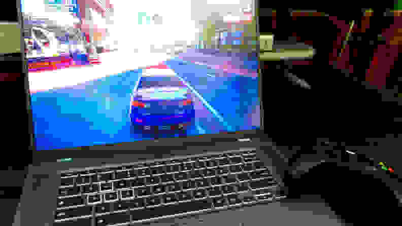 A video game on the screen of the Acer Chromebook laptop next to a video game controller.
