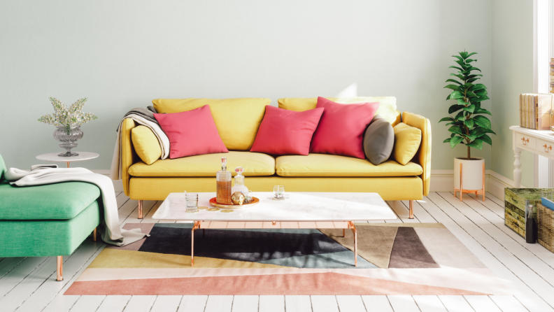 A brightly decorated living room: painted hardwood floor, marble coffee table, chic rug, Mad Men-esque 1960s color palette, potted plant in the corner.