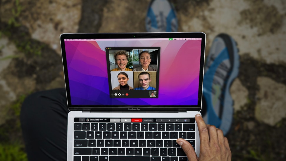 An open laptop showing four faces on the screen