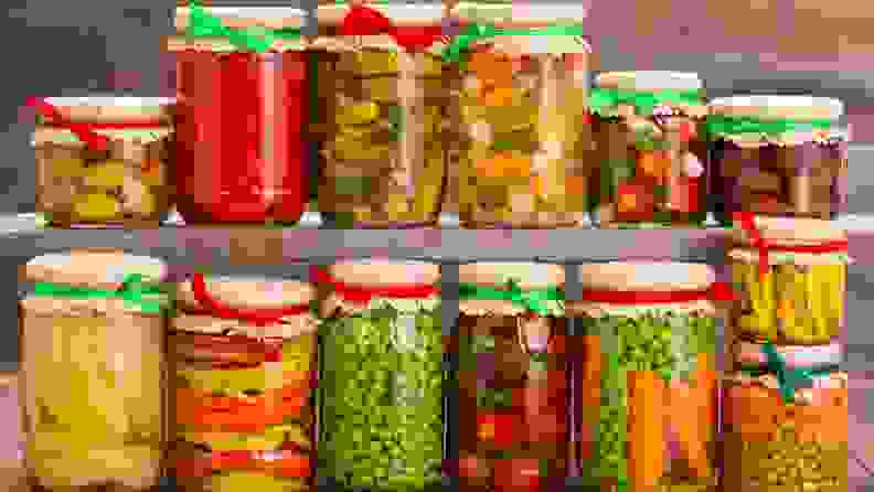 Two shelves lined with produce-filled jars.