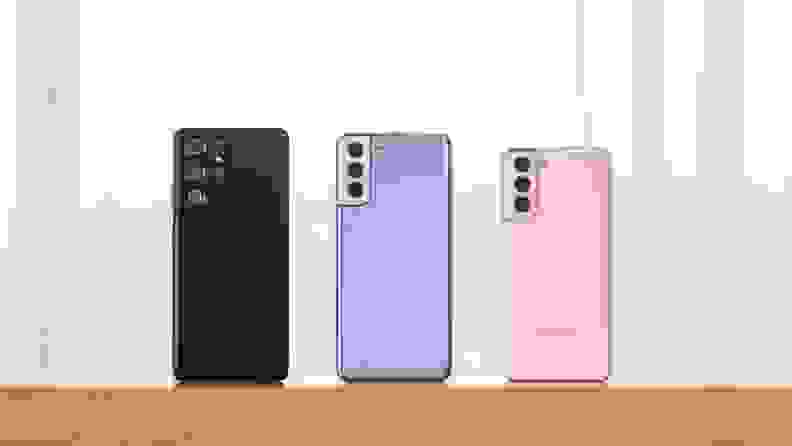 Three Samsung phones next to each other, in black, purple, and pink.