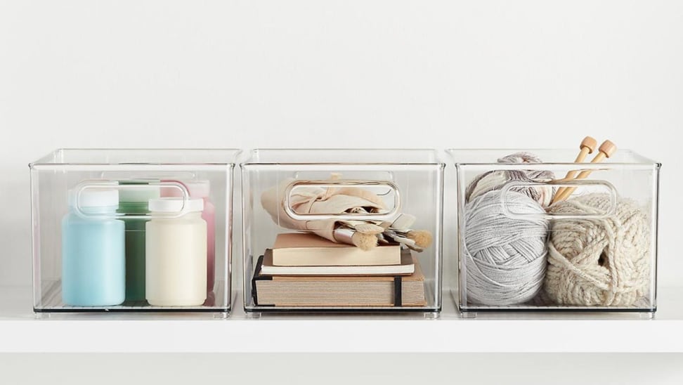 Clear containers on shelf holding craft items.