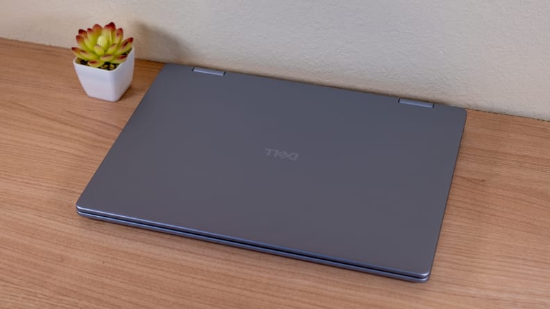 A closed silver laptop sits on a brown desk