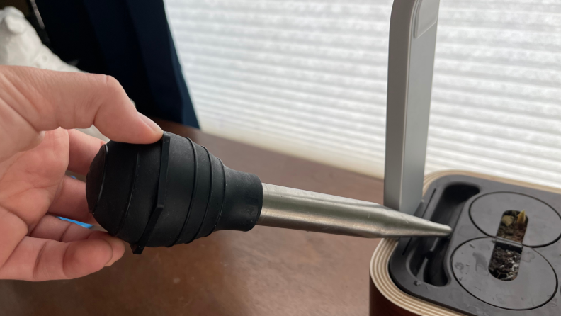 Watering an indoor smart garden with a turkey baster.