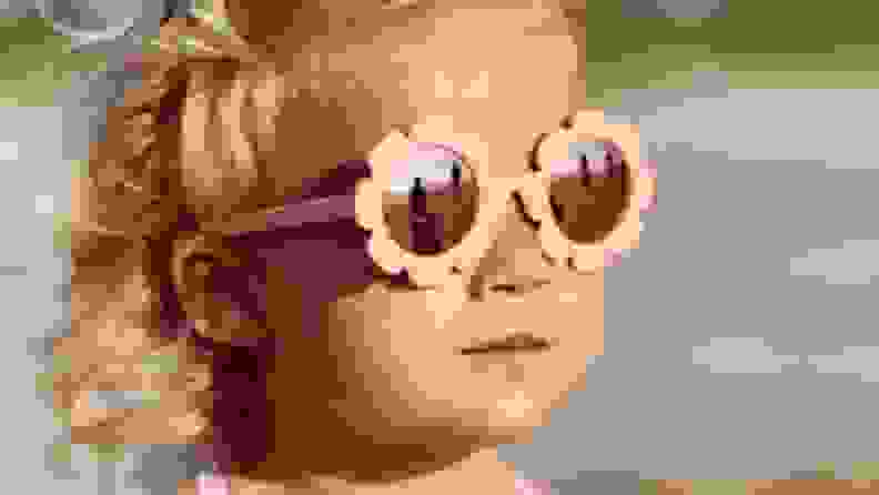 A girl with adorable pink flowered sunglasses.