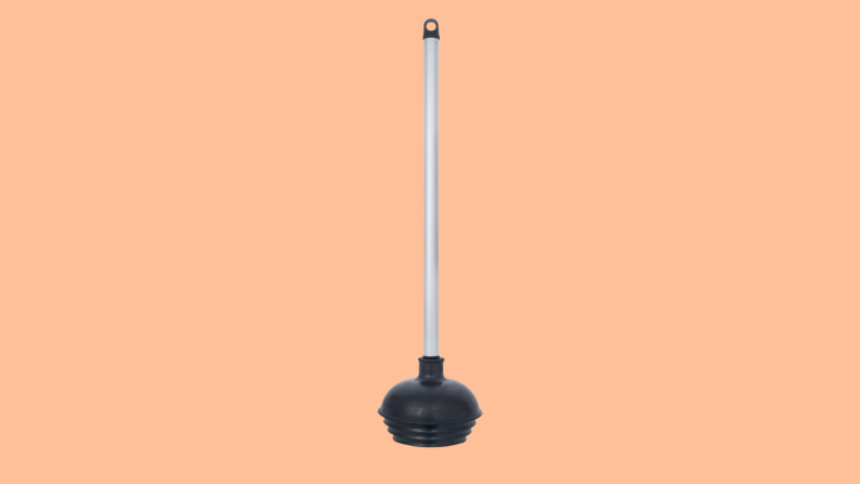 A toilet plunger against a peach background.