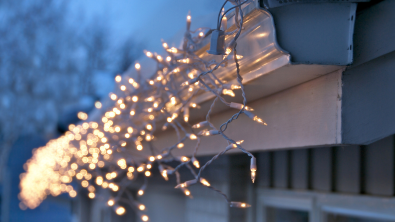 Christmas lights hanging from gutter of a home.