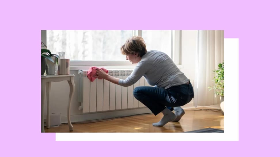 A person wipes their radiator clean of dust.